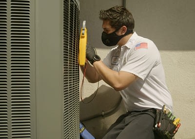 Magnolia technician wearing mask servicing HVAC