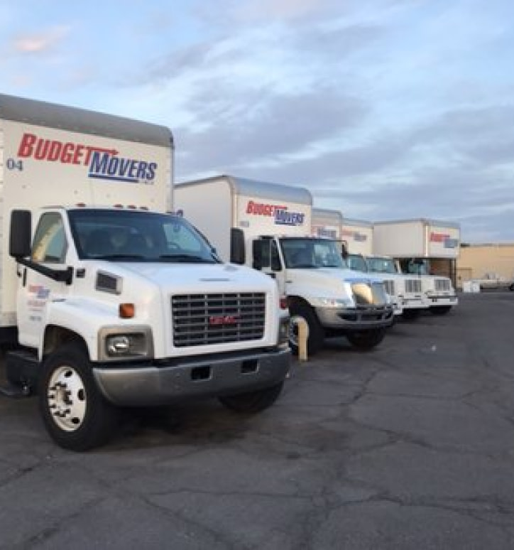 A lineup of moving trucks proudly displaying the logo of Budget Movers