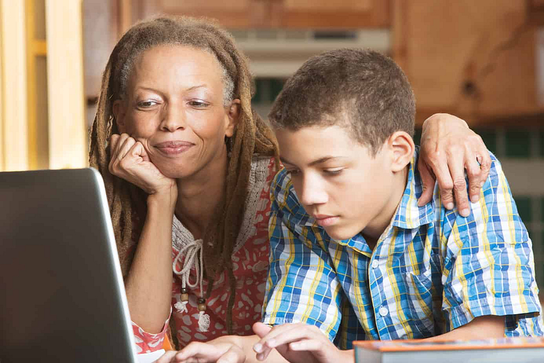 Talk with your kid about parental controls - mother and son in front of a computer