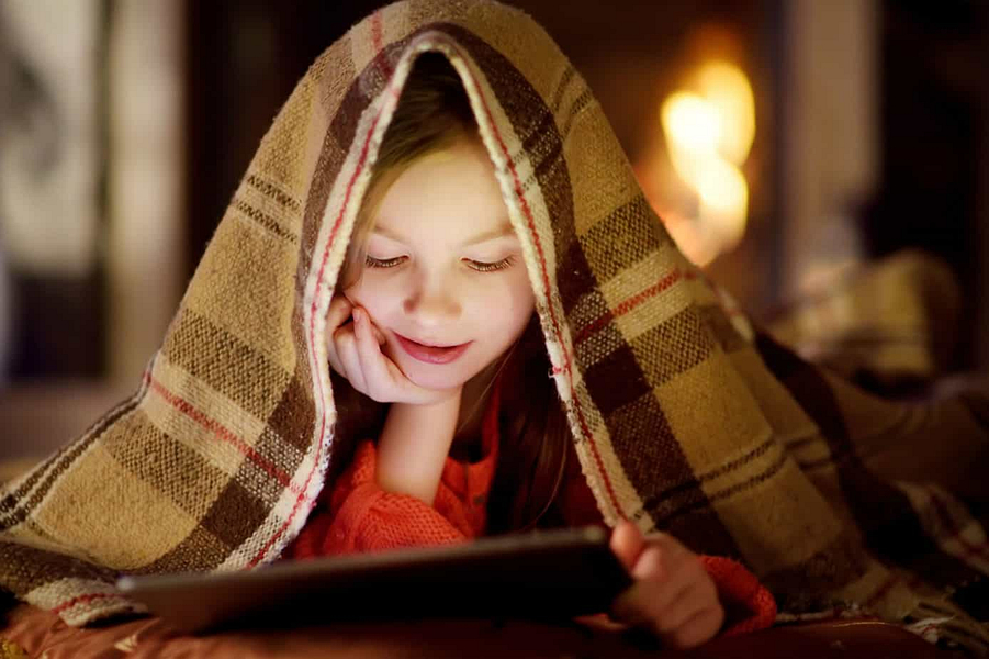 Managing Screen Time For Kids Girl on an iPad by a Fire