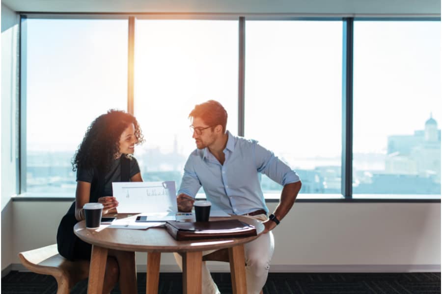 man and woman sitting at a table discussing paperwork