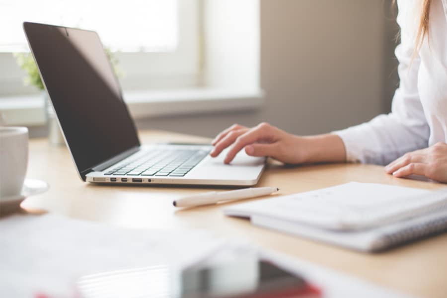 a woman working on a laptop at a desk