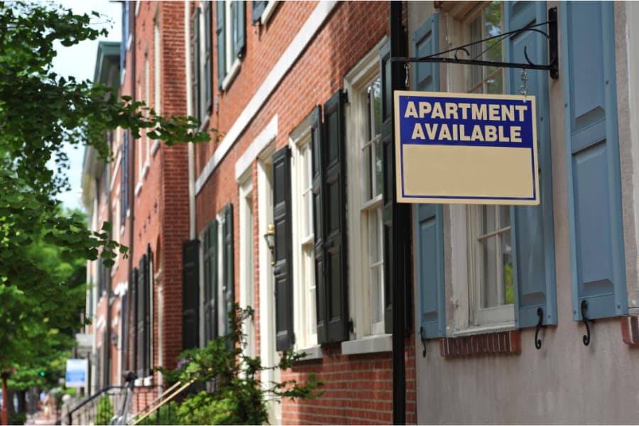 a row of philadelphia houses with an apartment available sign outside
