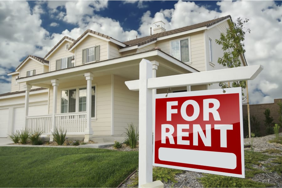 a large house with a for rent sign outside