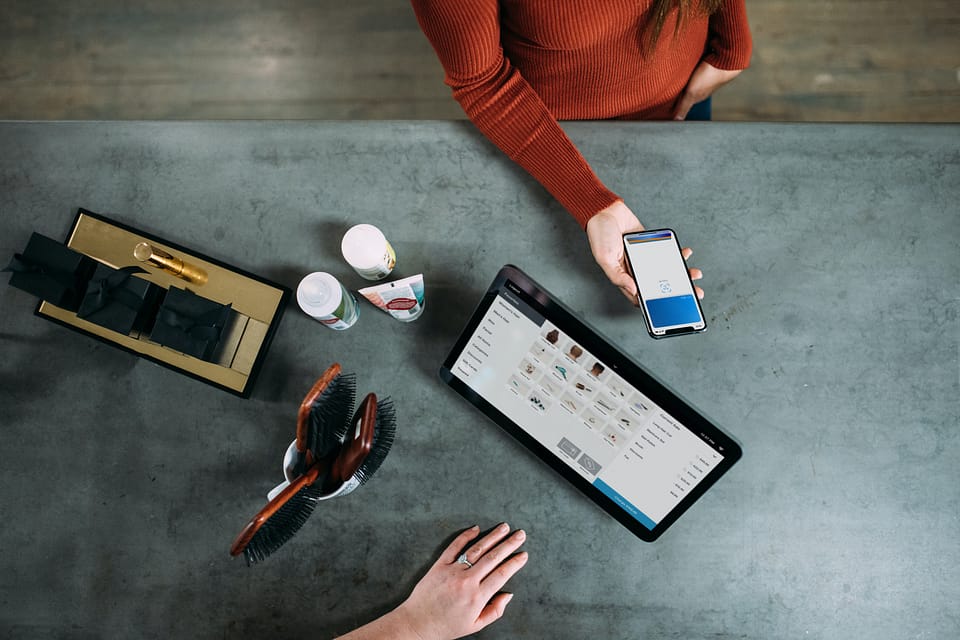 two people discussing mortgage payments over a table with a phone and tablet