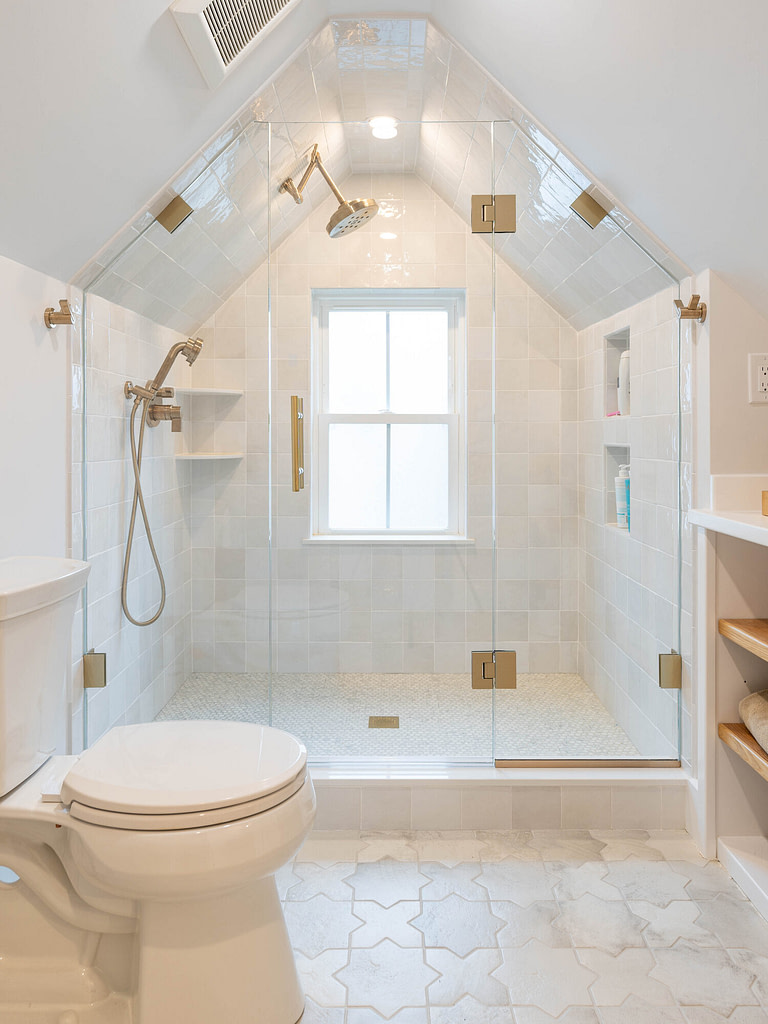 Custom frameless glass shower enclosure fitted to a sloped ceiling by Oasis Shower Doors