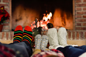 family warming their feet by the fireplace