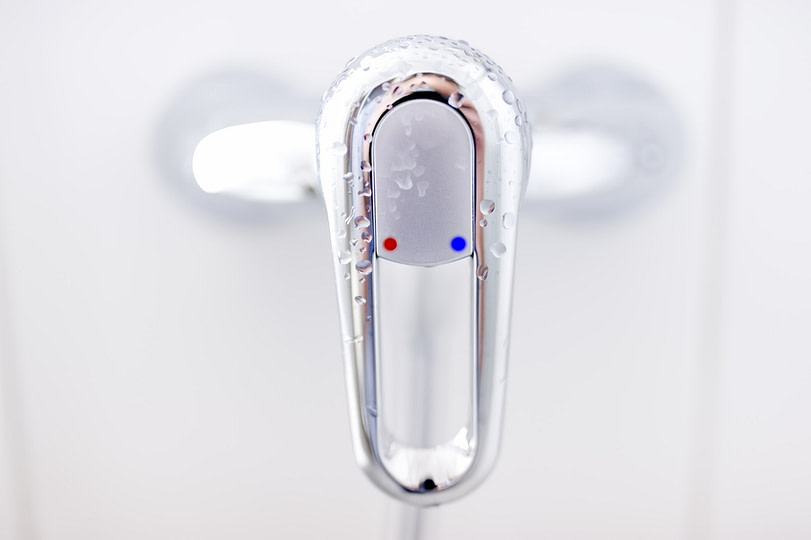 close-up of modern bathroom tap with cold and water symbols