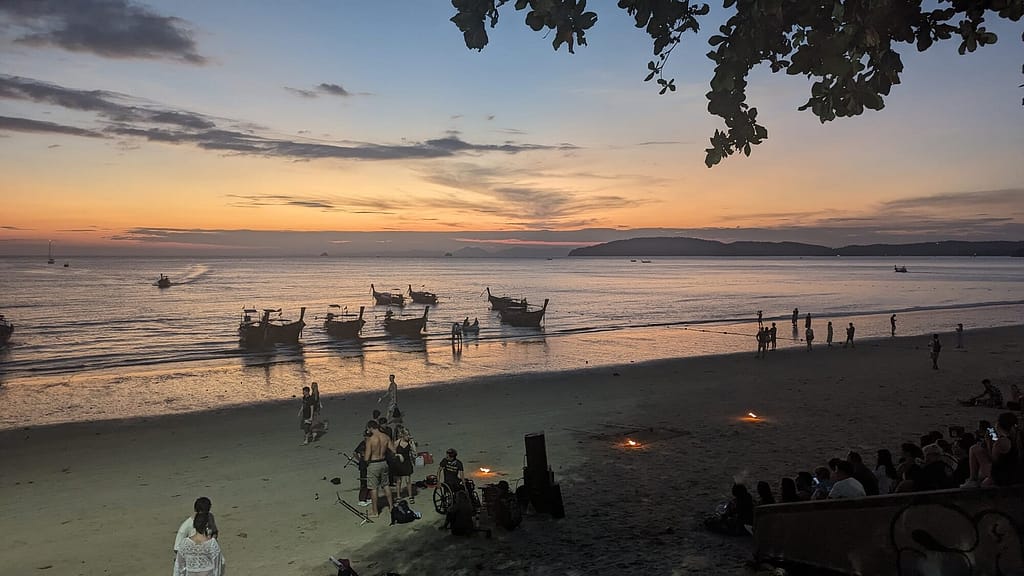 aonang beach at sunset with longtail boats on the shoreline