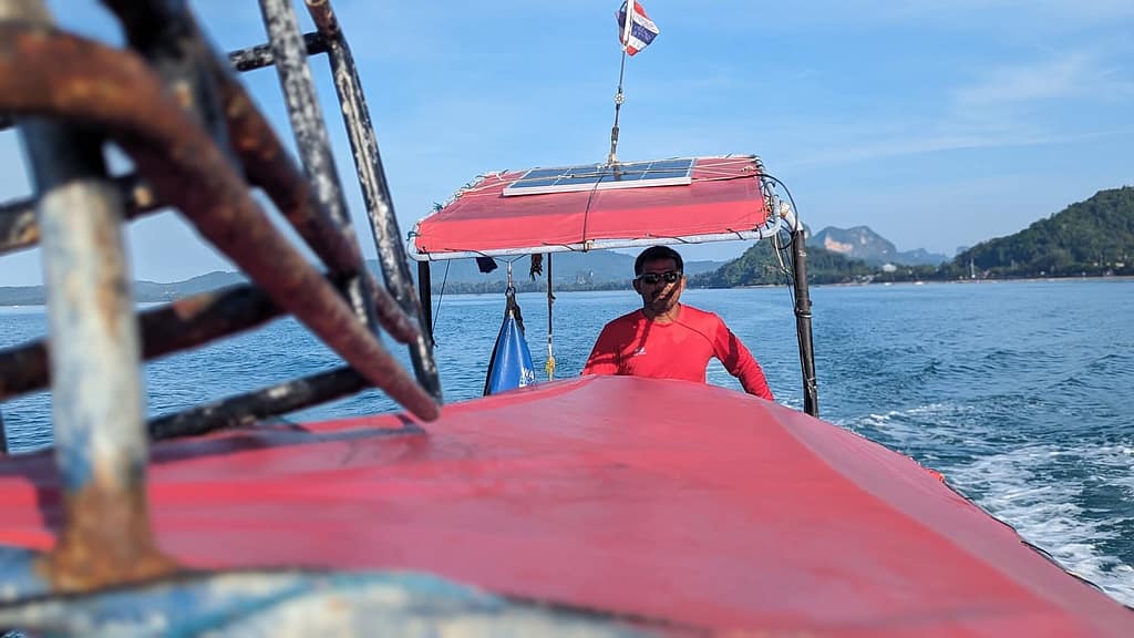 mirando desde la parte superior de un barco de cola larga hacia el conductor en la parte trasera