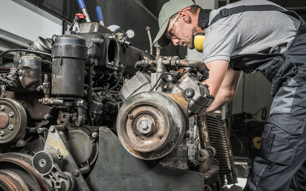 A mechanic servicing a diesel engine