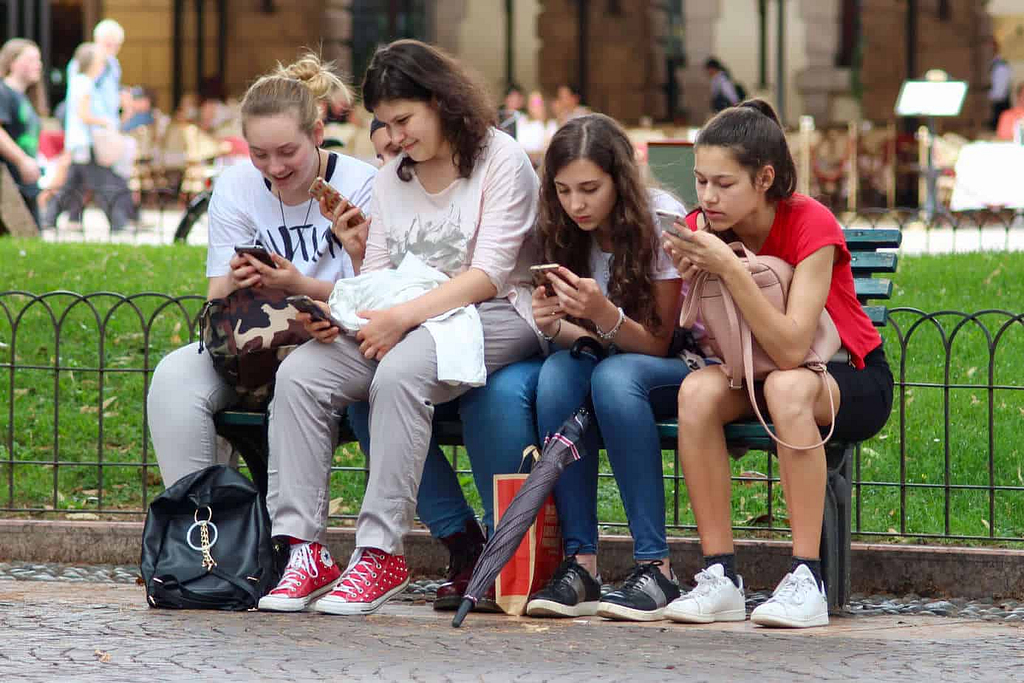 Tips for Internet Safety for Kids - four girls on a bench on cell phones