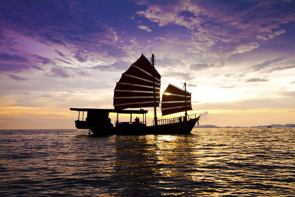 Silhoutte de invitados en un barco de Krabi Sailing Tour en un Krabi Sunset Cruise con la puesta de sol de fondo