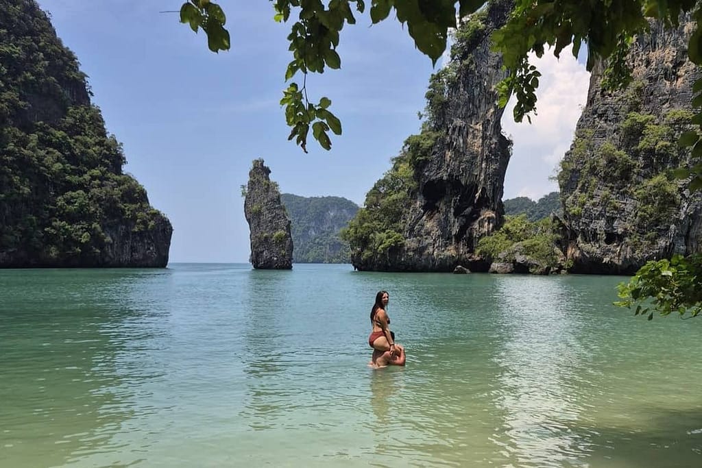 couple in the water at hong island with the limestone cliffs in the background