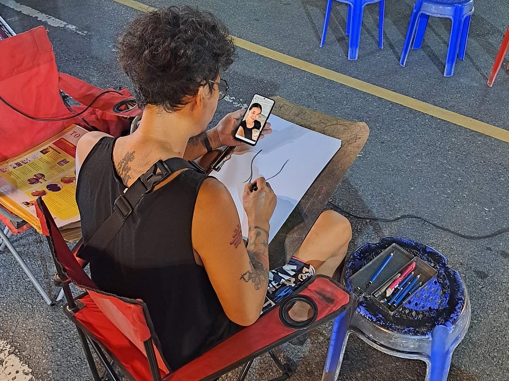 Artiste caricaturiste du marché de nuit de Krabi