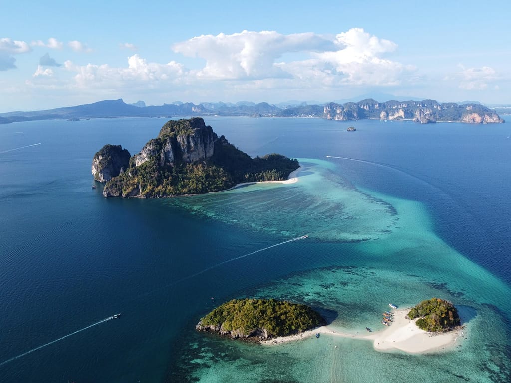 Krabi drone photography - aguas azules con dos islas con playa de arena en primer plano