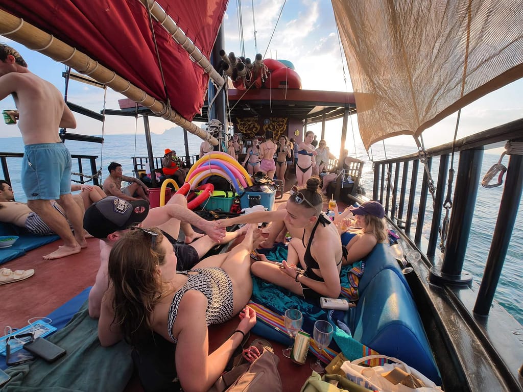 contiki group members lying on the deck of a pirate boat in thailand