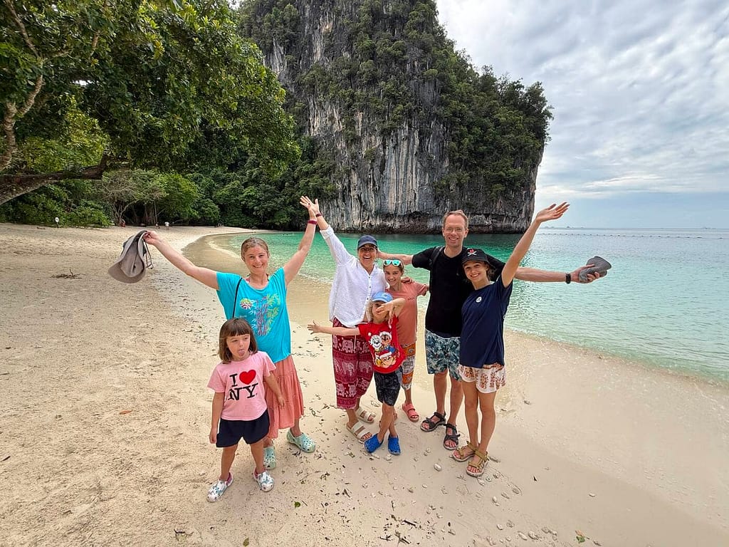 group posing on a beach with cliffs in the background
