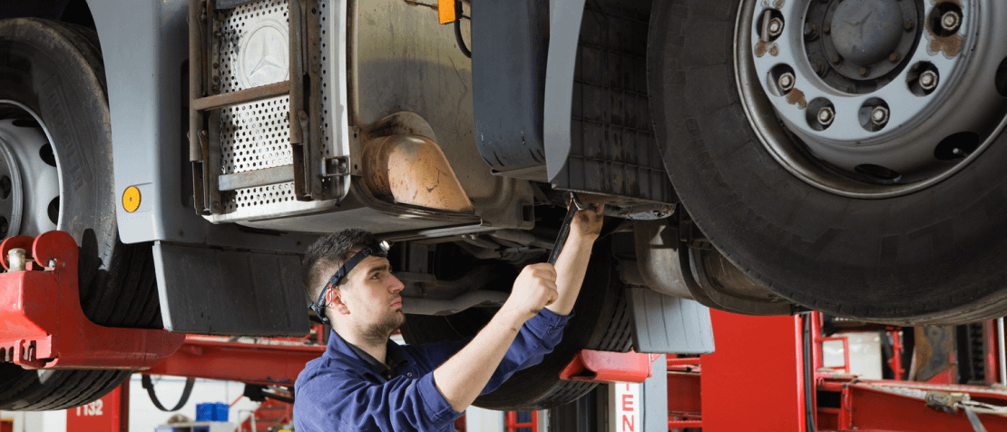 A diesel repair specialist working on a truck in a garage