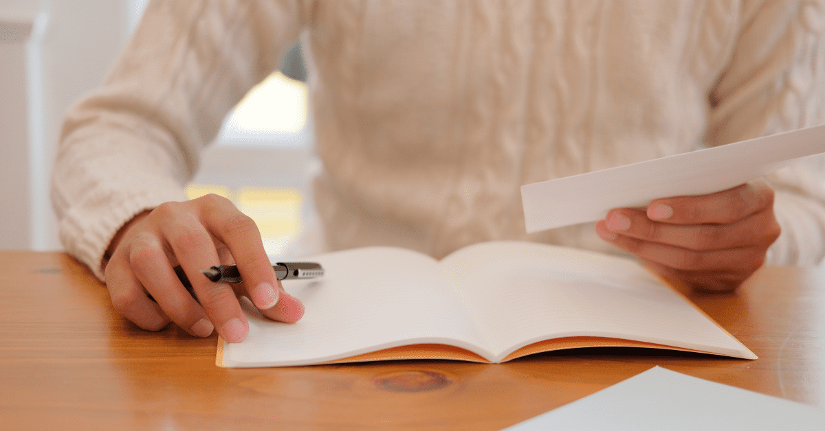 How Do House Cleanouts Work? 5 Tips To Keep in Mind 3 Person sat at table with pen and notepad