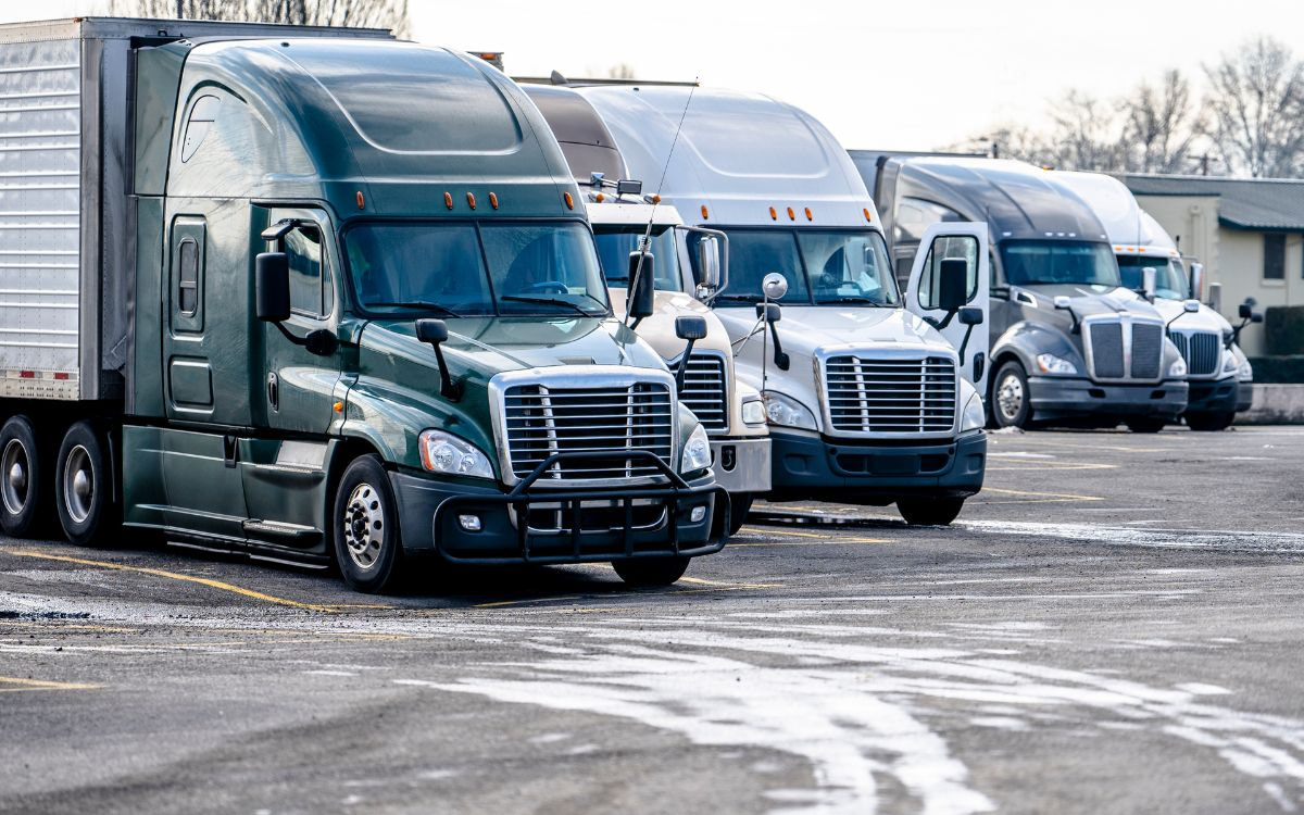 A row of semi trucks parked in a parking lot