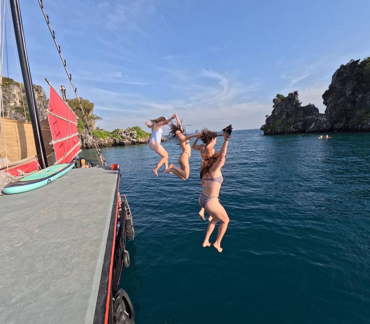 Huéspedes saltando desde la terraza de la azotea al mar durante un crucero por las islas de Krabi