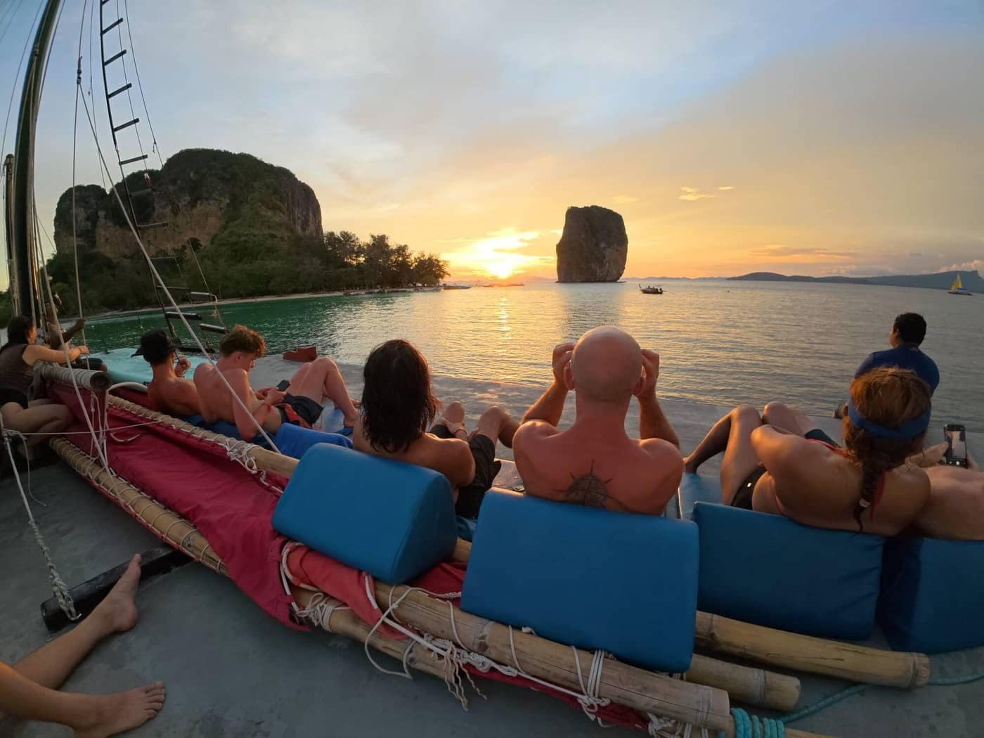 Huéspedes que se relajan en la terraza de la azotea mientras contemplan la puesta de sol cerca de la isla de Poda, en Krabi