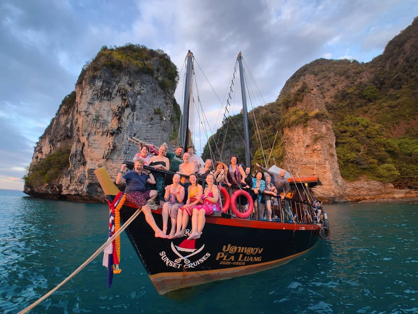 Un grupo privado posando en la proa del barco de Krabi Sunset Cruises durante una excursión a cuatro islas.