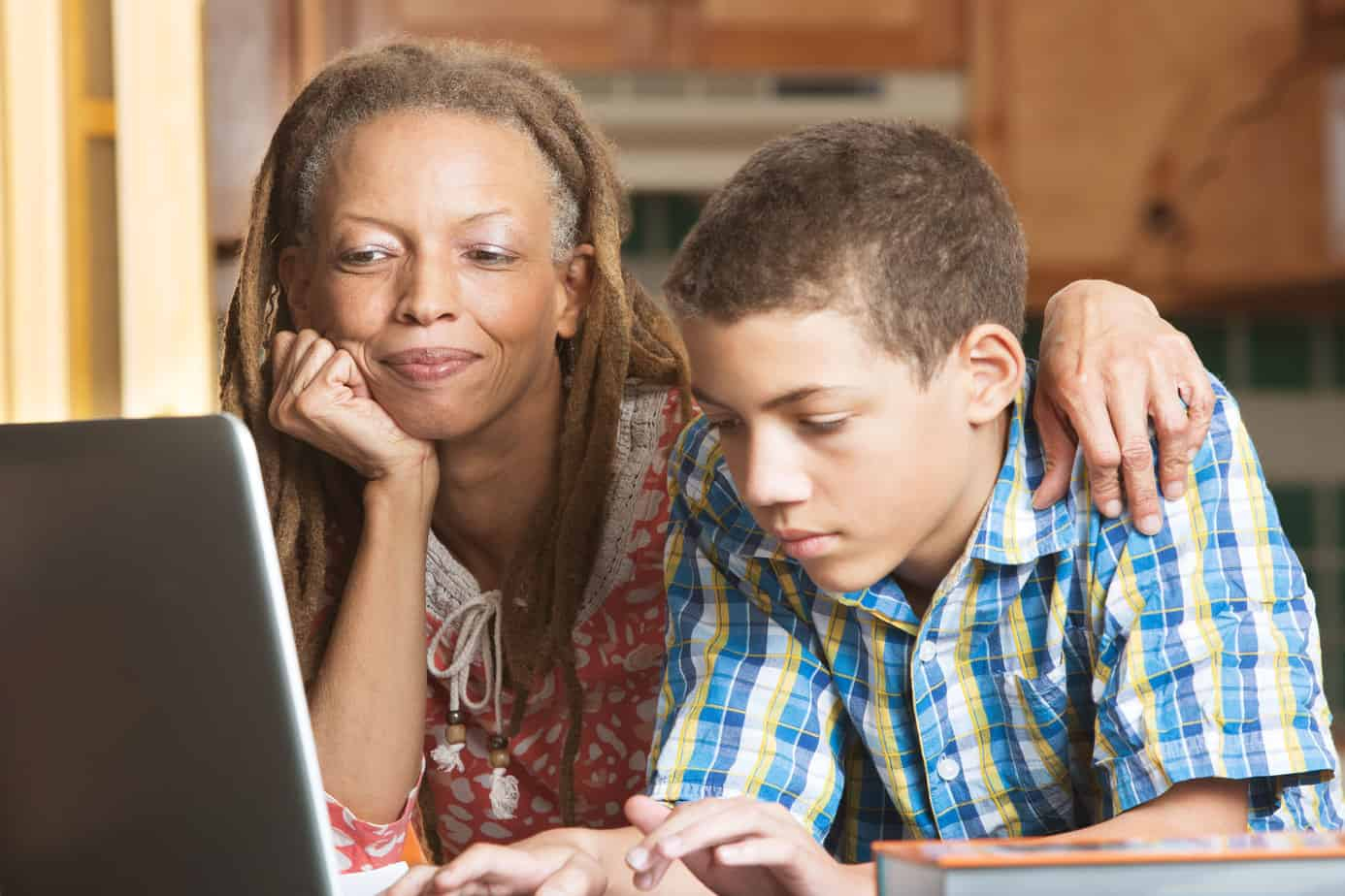 Talk with your kid about parental controls - mother and son in front of a computer