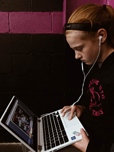 Young Teen Girl On A Laptop With Headphones
