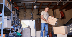 How Can I Empty My House Quickly? Step-by-Step Guide 1 Person stacking cardboard boxes in garage
