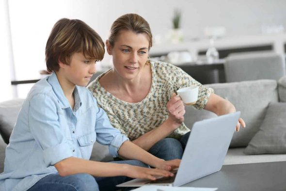 Mother teaching son about kids internet safety on laptop