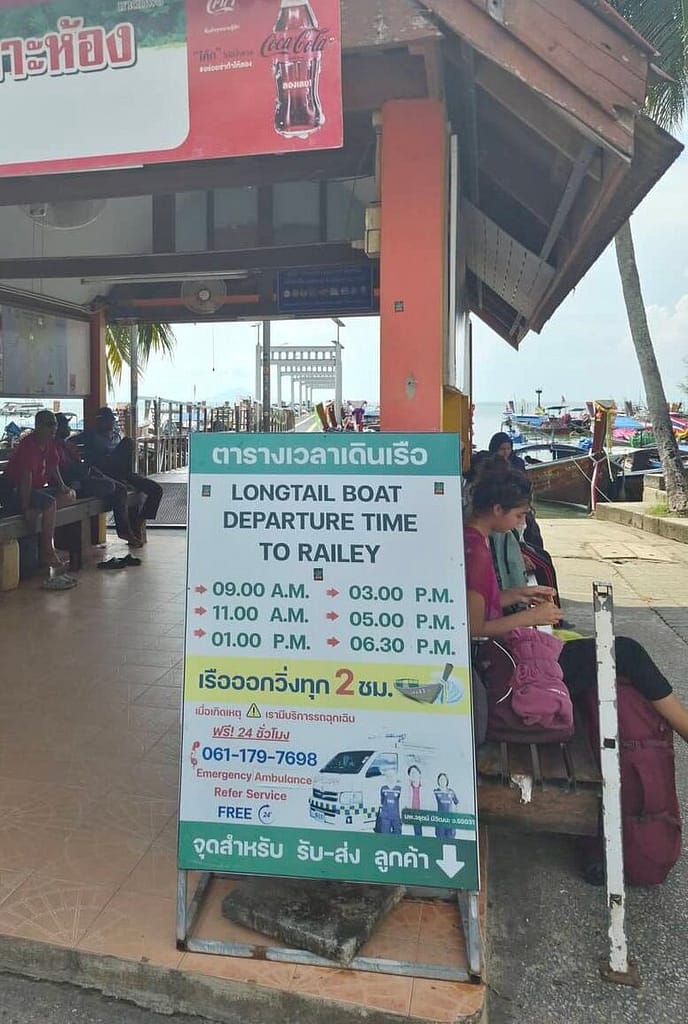 Oficina de venta de boletos de barco Longtail en el muelle de Ao Nam Mao, en Krabi, Tailandia, con horarios de salida para los barcos que van a la playa de Railay.