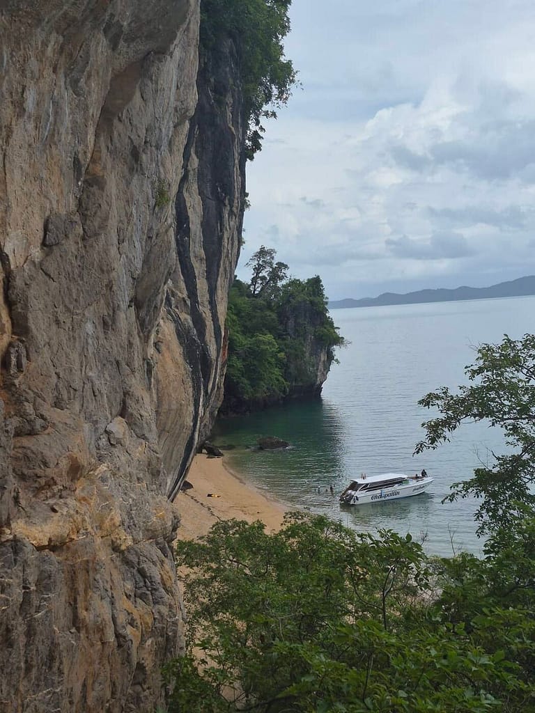 Una lancha rápida anclada junto a una playa recóndita, al pie de unos acantilados de piedra caliza, en la bahía de Phang Nga