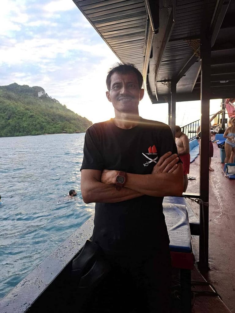 Gun, barman et matelot chez Gun, Krabi Sunset Cruises, debout à bord du bateau