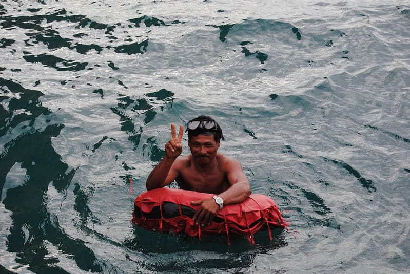 Le capitaine de Krabi Sunset Cruises fait une démonstration des règles de sécurité aquatique à l'aide d'une bouée de sauvetage