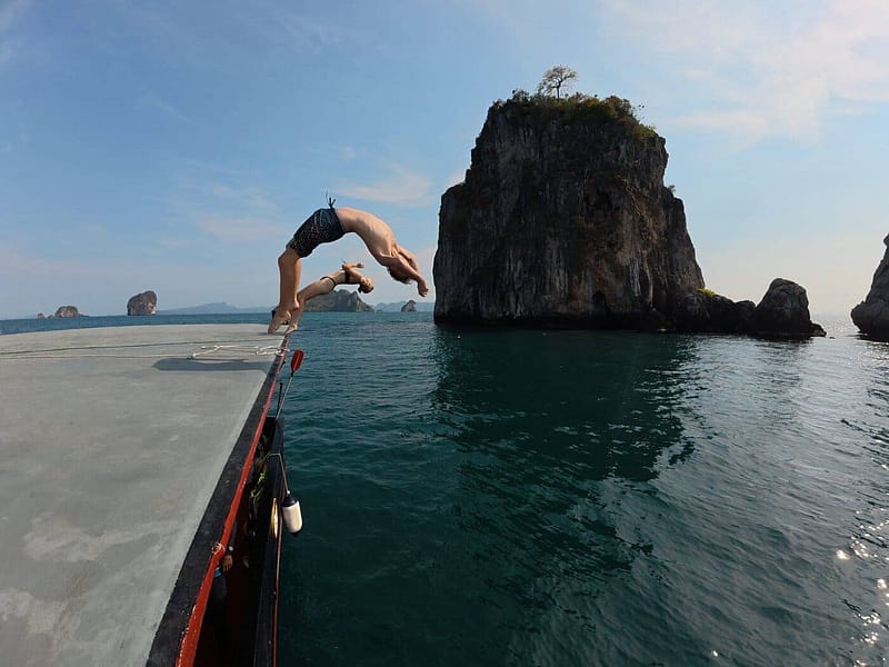 Deux clients plongeant depuis la terrasse sur le toit du Pla Luang dans la mer, près d'une île calcaire à Krabi.