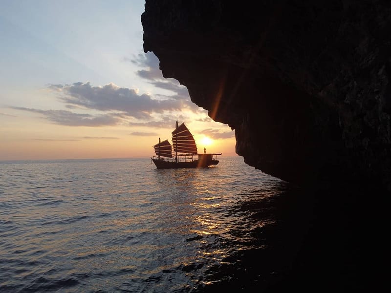 Junk boat with red sails during sunset