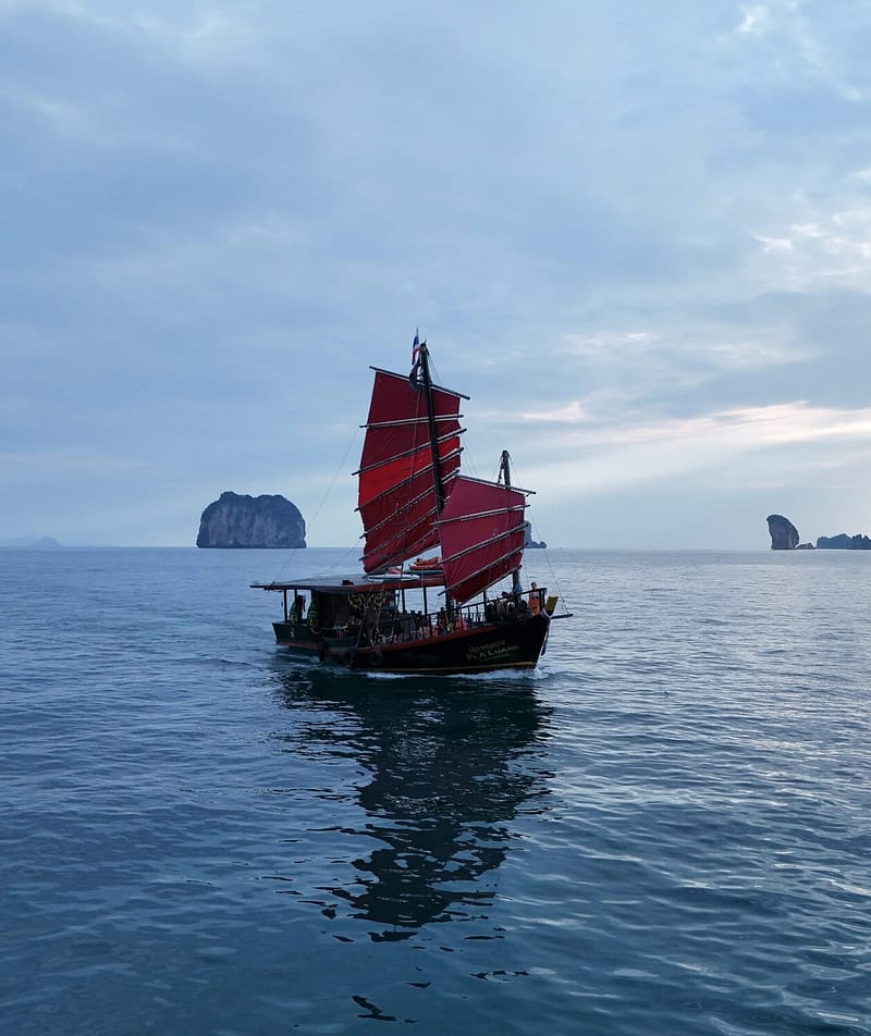 Traditional Siamese junk boat cruising between the Krabi islands