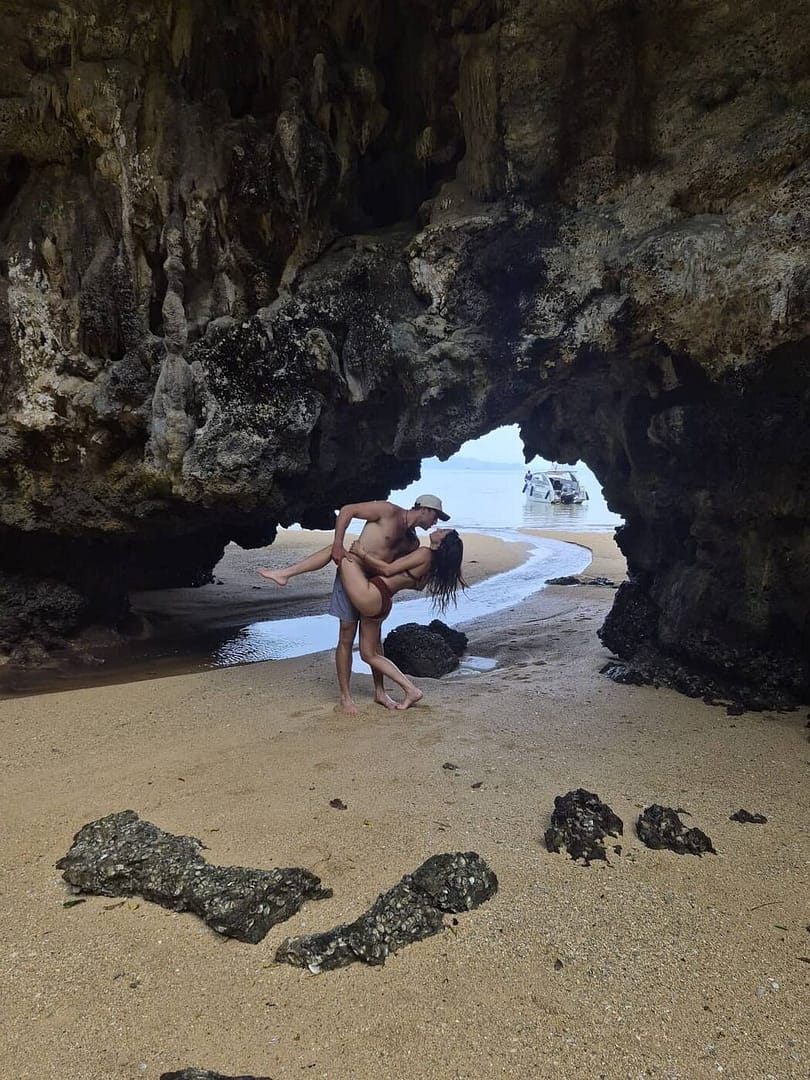Pareja posando delante de la entrada de una cueva en Krabi