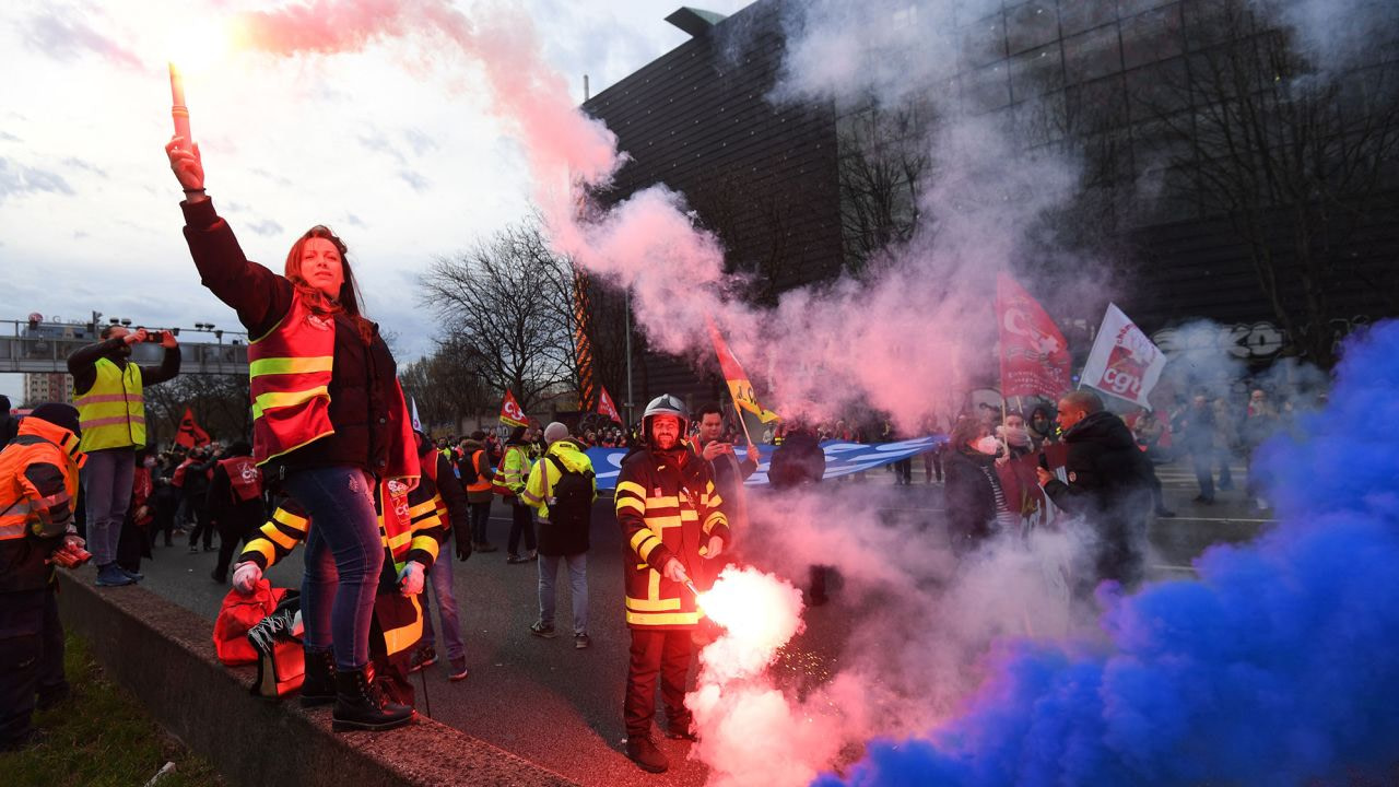 CGT unionists light flares on the ring road as they block the traffic in Paris on March 17, 2023.