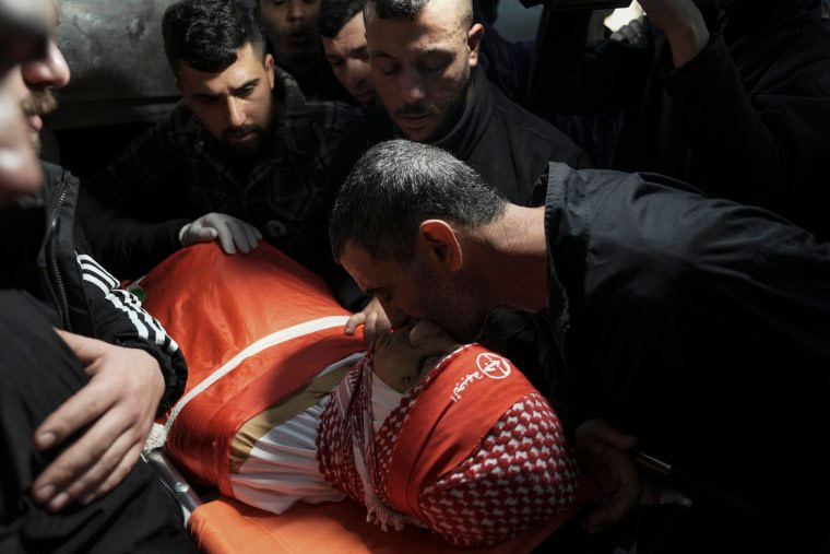 Mourners gather around the body of 14-year-old Palestinian Amr Khamour during his funeral in the West Bank city of Bethlehem on Jan. 16.