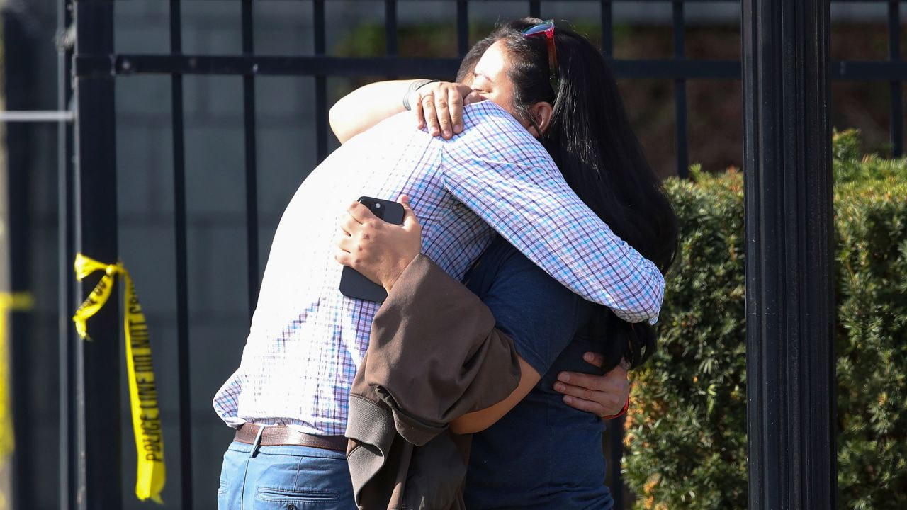Two people embrace outside the building where a mass shooting happened in Louisville on Monday.