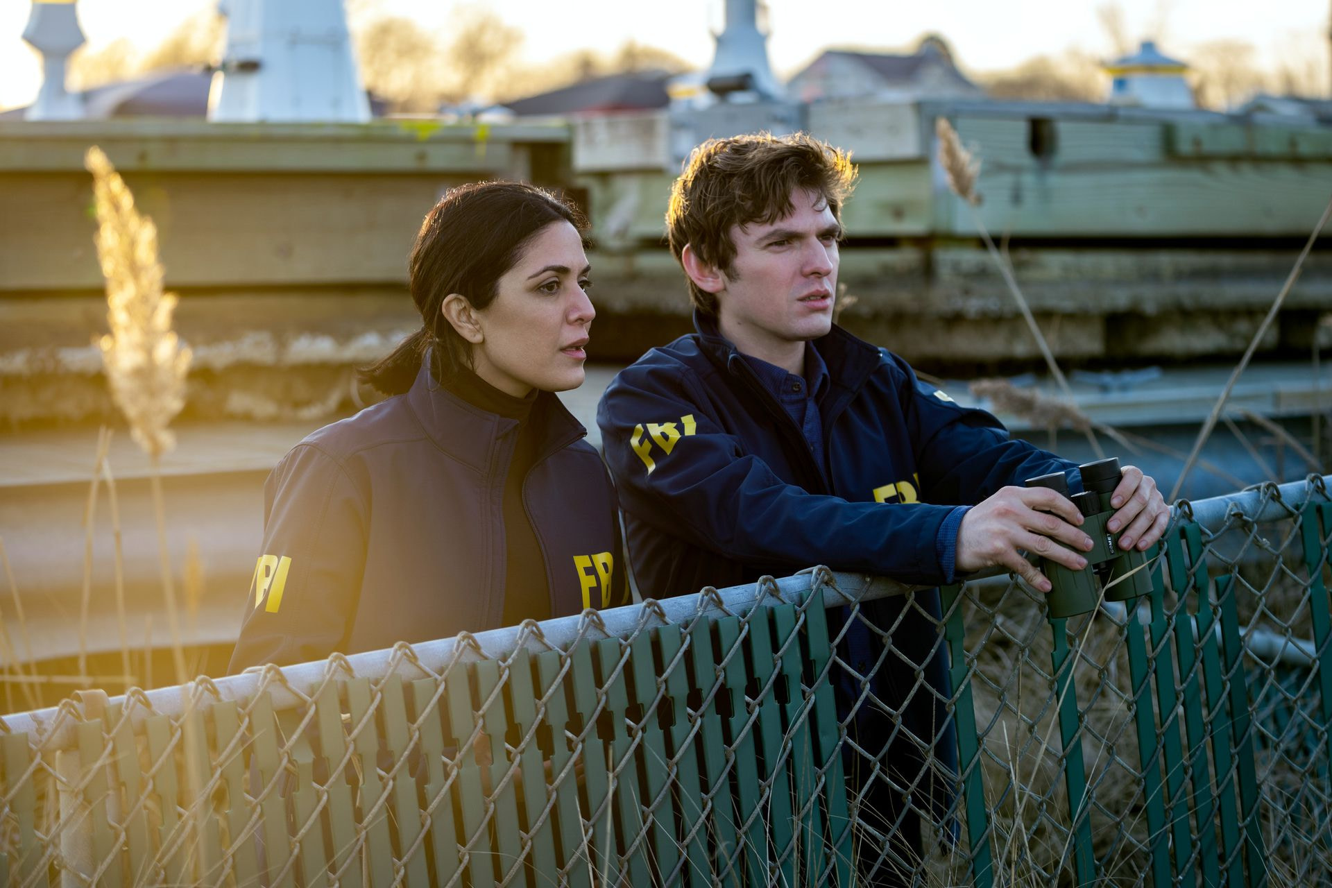 Two FBI agents in Netflix’s Kaleidoscope stand on a fence