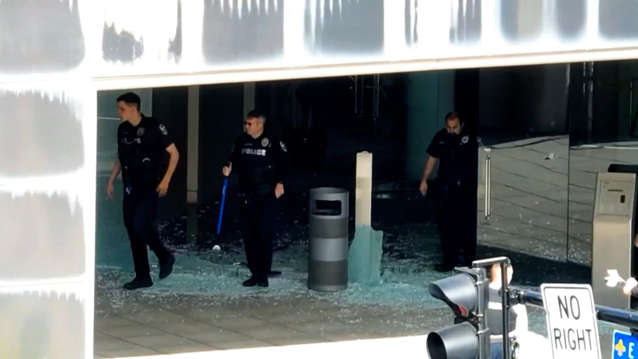 Police step on shattered glass at the Old National Bank in Louisville, Kentucky, on Monday after a mass shooting.
