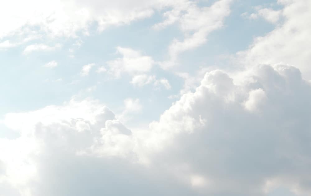 Nuages floconneux sur fond bleu pâle
